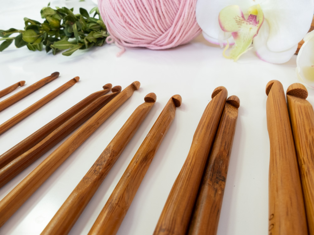 A group of wooden knitting needles and a ball of yarn.