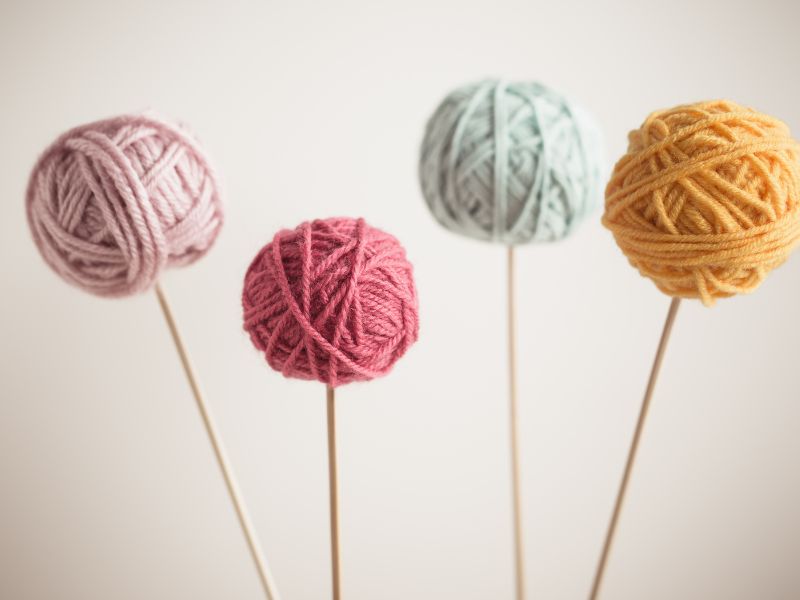 A group of yarn balls on a stick.